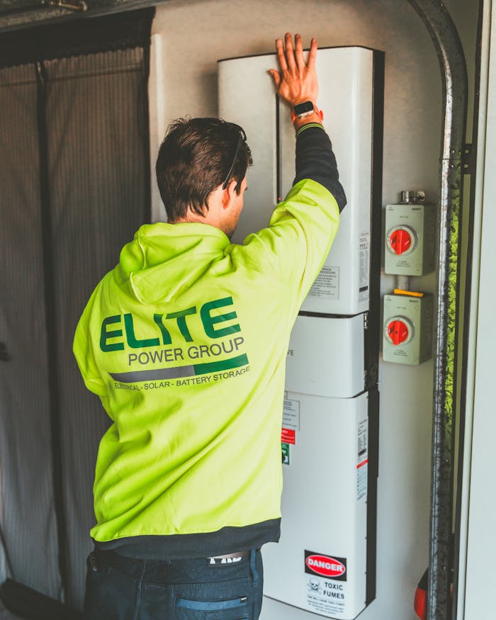 why-choose-us Technician installing a solar inverter and battery system in New South Wales.